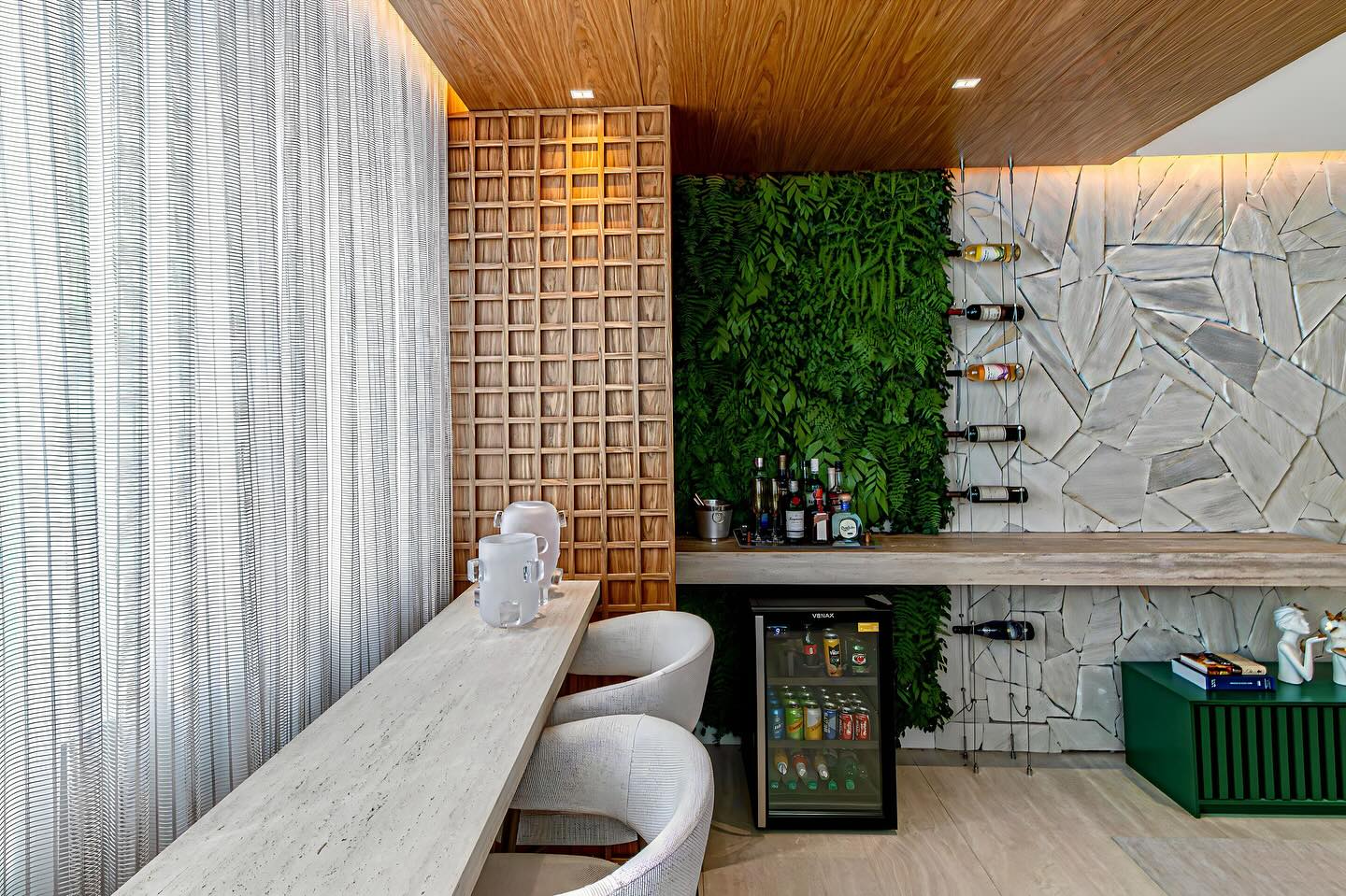 Área gourmet com bancada em pedra e jardim vertical